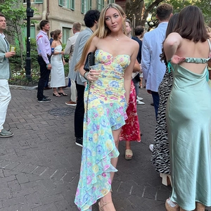Detail of floral off-shoulder maxi dress featuring ruched chest and ruffled fishtail hem
