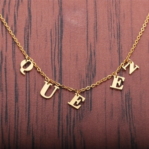 Golden stainless steel chain necklace featuring QUEEN letter pendants on wood surface