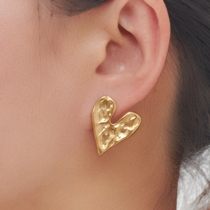 Detailed view of gold irregular molten heart earrings with unique metallic textured finish