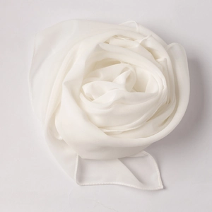 Detail of soft white chiffon scarf texture with delicate rolled hem and rose-fold design