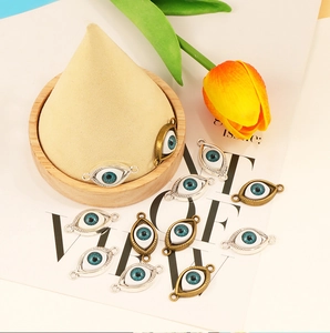 Macro view of blue evil eye charms in silver and bronze metal frames for DIY jewelry
