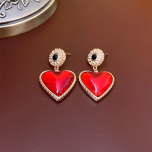 Vintage heart earrings in red with gold trim and black bead detail for a retro look