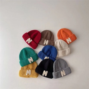 Multi-color kids knit beanies with N letter patch in various vibrant autumnal shades