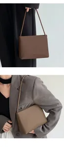 Detail of minimalist brown leather shoulder bag styled with chic business attire