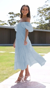 Detail of light blue off-shoulder dress with tiered skirt and puff sleeves in outdoor light