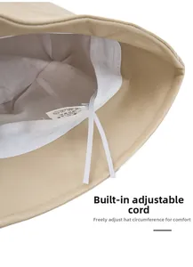 Detail view of the interior lining and adjustable drawstring of beige PU leather bucket hat