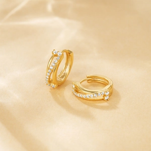 Detailed close-up of golden s925 silver huggie hoops with sparkling micro-pave zircons