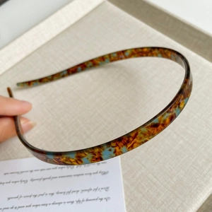 Detail van de flexibele acetaat hoofdband met bruine amber en blauwe schildpadprint