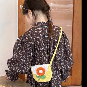 Girl wearing floral dress with a yellow hand-knitted sunflower crossbody shoulder bag