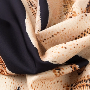 Macro shot of fabric texture showing leopard animal print and subtle beige fabric folds