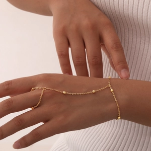 Detail of 18K gold-plated stainless steel hand chain with circular gold bead accents