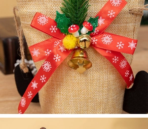 Macro detail of Christmas gift bag featuring red ribbon bow, gold bell and linen texture