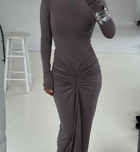 Détail de la robe longue ajustée à manches longues avec taille froncée et tissu plissé