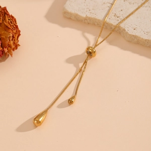 Elegant gold-plated waterdrop Y-necklace with polished finish on a minimalist stone background