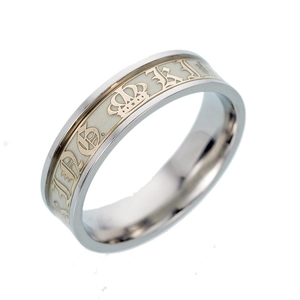 Detail of wide stainless steel ring with luminous white inlay and golden crown pattern