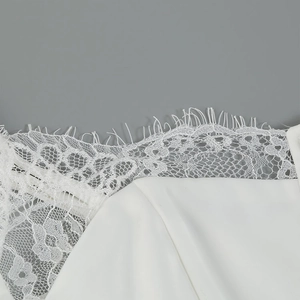Detailed close-up of intricate white floral lace patterns and delicate fabric texture