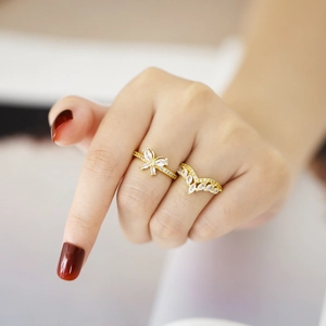 Golden butterfly and V-shaped ring set with marquise zircons shown on a hand