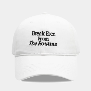 White cotton baseball cap with Break Free From The Routine black letter embroidery