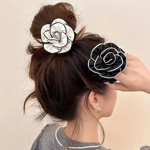 Elegant camellia flower hair scrunchies in black and white styles on a ponytail