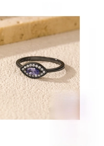 Detail of dark metal ring with marquise purple stone and matching cross bracelet