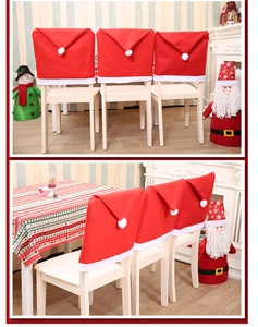 Three red Christmas hat chair covers with white fur trim on wooden dining chairs