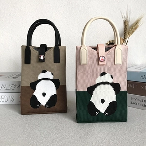Detail of knitted panda tote bags in khaki and pink colors with stylish woven patterns