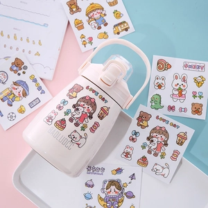 Pink cartoon children's thermos bottle with cute stickers and straw on a tray