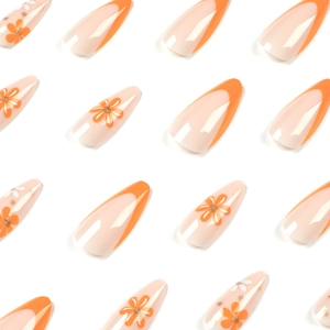 French tip press-on nails with orange and white floral patterns and golden glitter accents