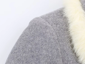 Detail view of the gray woolen coat featuring soft beige faux fur trim on the collar