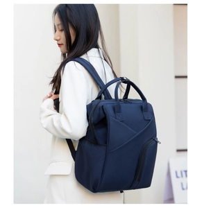 Detail of dark blue waterproof nylon diaper bag with reinforced stitching and side pockets
