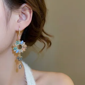 Vintage floral drop earrings with colorful crystals and fringe tassels on a model