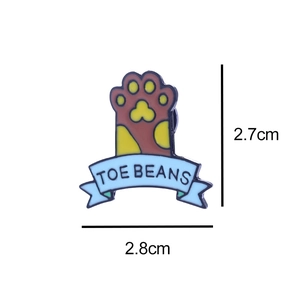 Detail view of cat paw enamel pin with TOE BEANS text showing 2.8cm x 2.7cm dimensions