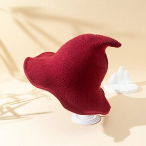 Knitted pointed witch hat in deep burgundy wine red for Halloween and autumn fashion