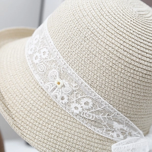 Women's French straw sun hat featuring floral lace ribbons and a rolled edge for beach use