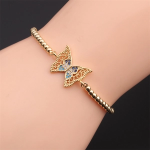Close-up of a gold-plated butterfly bead bracelet with colorful zircon on a model's wrist