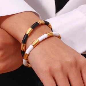 Fashionable black and white Y2K stainless steel bangles worn by a model on white background