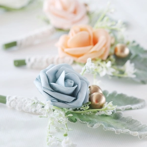 Elegant artificial rose boutonniere set for weddings with lace ribbon and foliage details