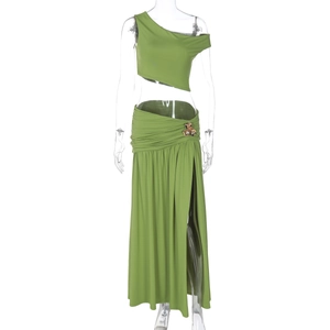 Detail of green one-shoulder crop top and high-slit ruched maxi skirt set on mannequin