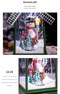 Détail d'une lanterne de Noël en forme de moulin avec bonhomme de neige et neige