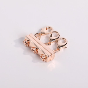Makro-Detail eines dreilagigen Magnet-Halskettenverschlusses in Roségold mit Karabinern