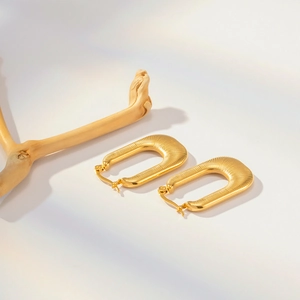 Détail de boucles d'oreilles en U plaquées or 18 carats avec texture torsadée et fermoir