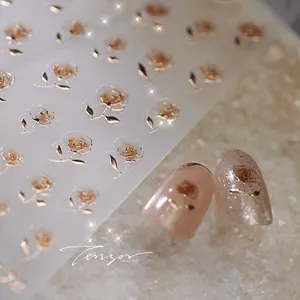 Macro shot of champagne gold 3D embossed rose nail stickers with metallic texture