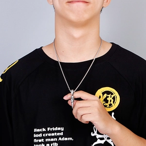 Close-up of men's retro steel bullet pendant and twisted chain on black shirt