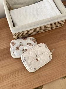 Quilted cotton storage pouches featuring brown bear and floral patterns on wooden table
