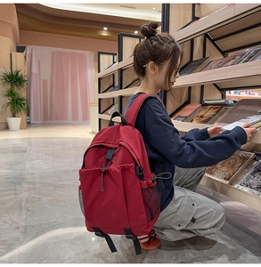 Dunkelroter Canvas-Rucksack mit Kordelzugtasche und seitlichem Netzfach im Detail