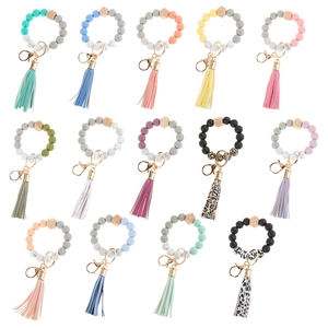 Multiple styles of silicone beaded bracelet keychains with leather tassels and wood accents