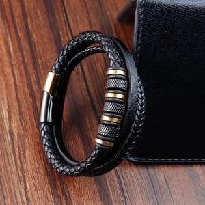 Men's multilayer braided leather bracelet with black and gold magnetic clasp on wood