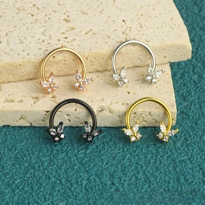 Detailed close-up of C-shaped butterfly nose rings in four different metallic finishes