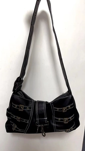 Detail view of black punk style tote bag with metal buckles and white contrast stitching