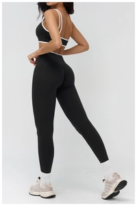 Detail of cross-back yoga bra and high-waist leggings with white piping for women